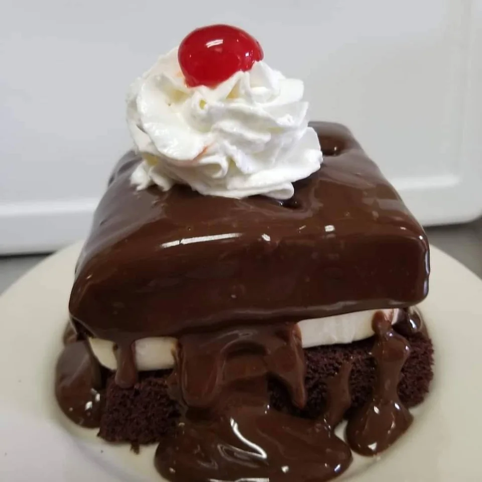 Trish’s best-selling fudge cake with chocolate, whipped cream and a cherry
