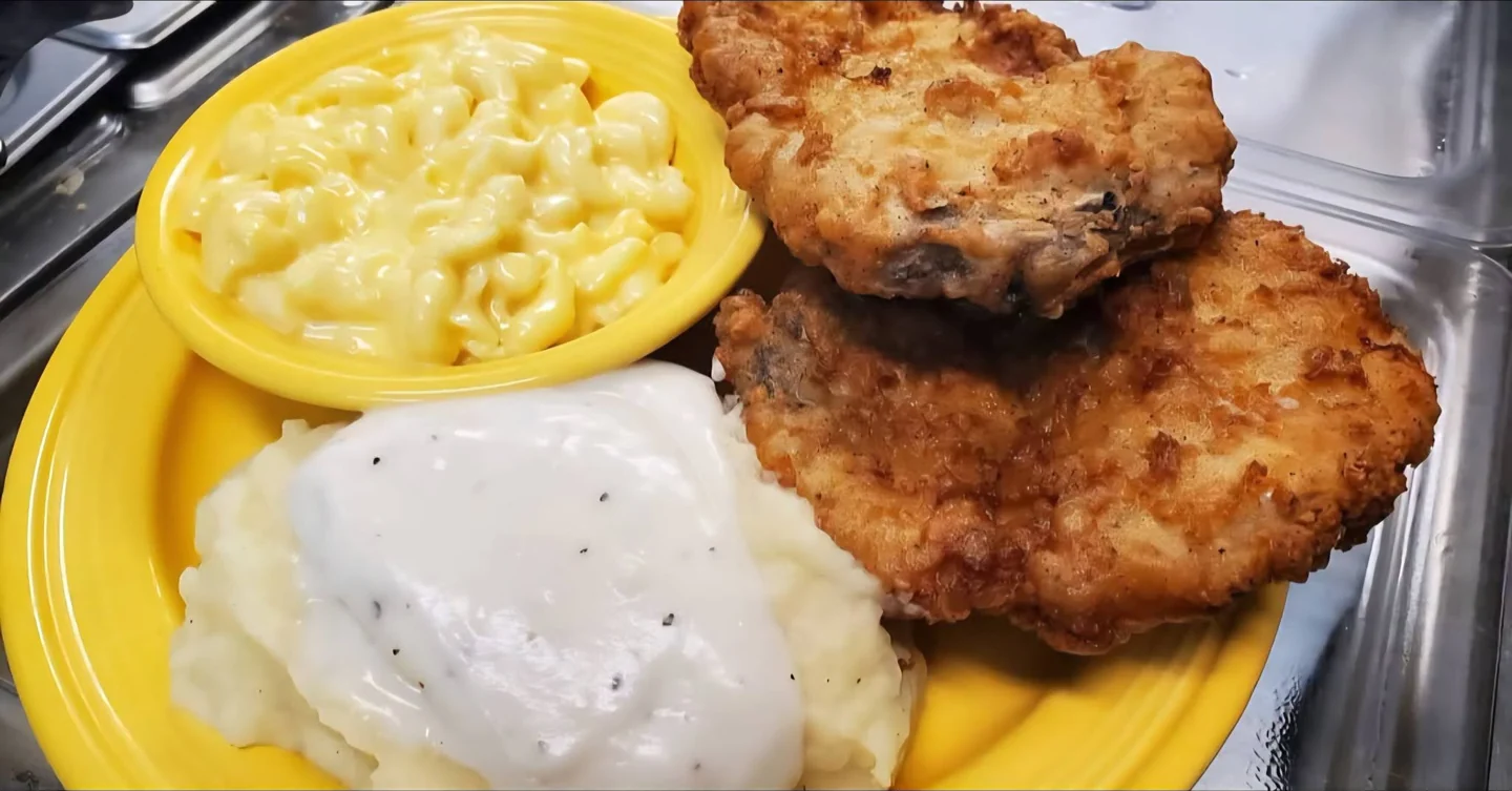 Two pork chops with mashed potatoes, gravy and macaroni and cheese